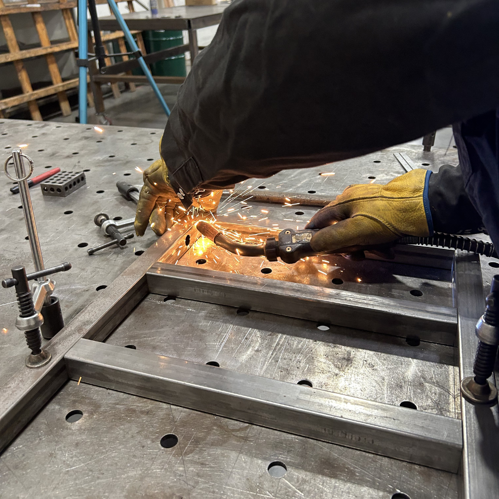 Welder using MIG gun to tack together DIY Hogue Rugged Welding Cart frame